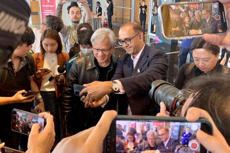 Nvidia chief Jensen Huang (centre L) poses for photographs before attending a press conference at Computex 2023 in Taipei on May